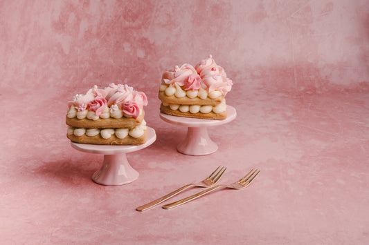 two cakes sitting on top of a white cake stand